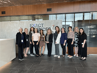 Exact Sciences team members and Patient Advocacy Advisory Council members pose for a group photo in front of the Exact Sciences logo.