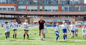 Dara Andringa leads a group of kids in drills on a soccer field