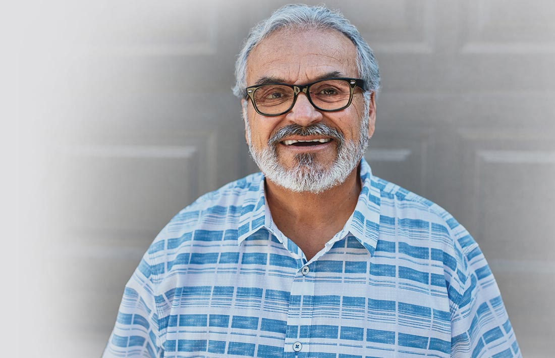 Smiling older man with glasses and a beard.