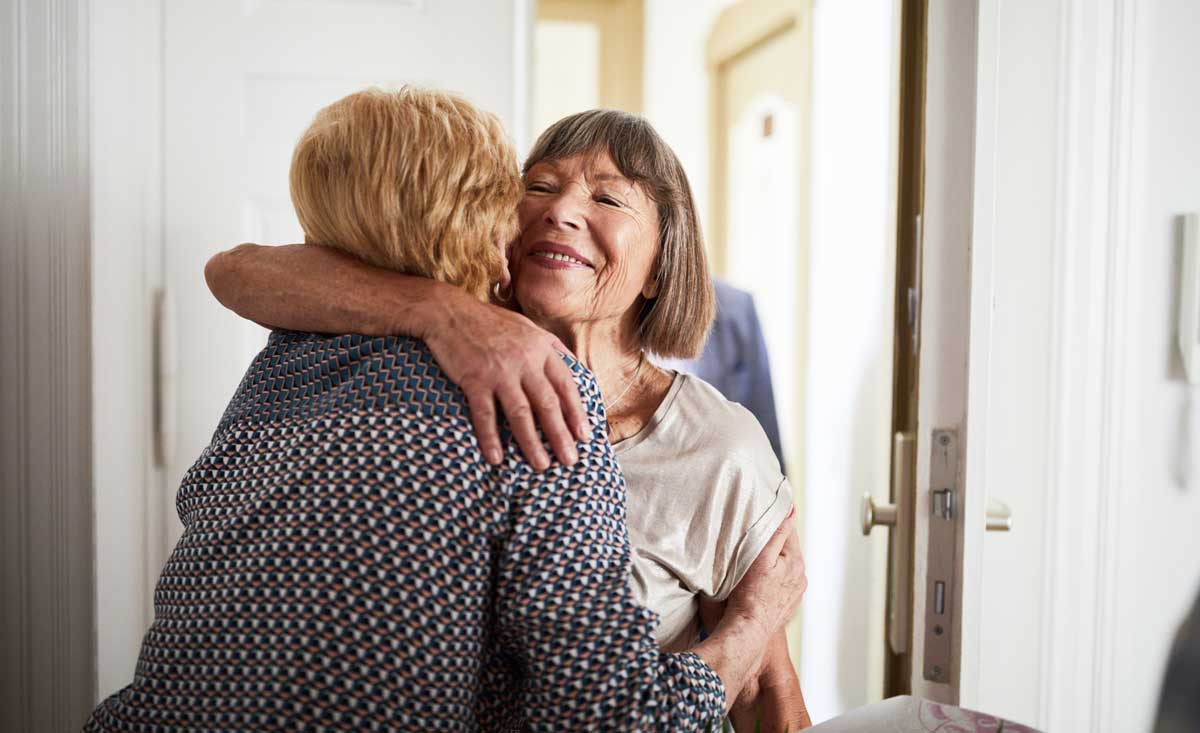 Two women embracing in a doorway.