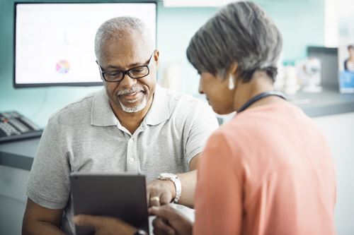 Healthcare provider and patient reviewing information on a tablet